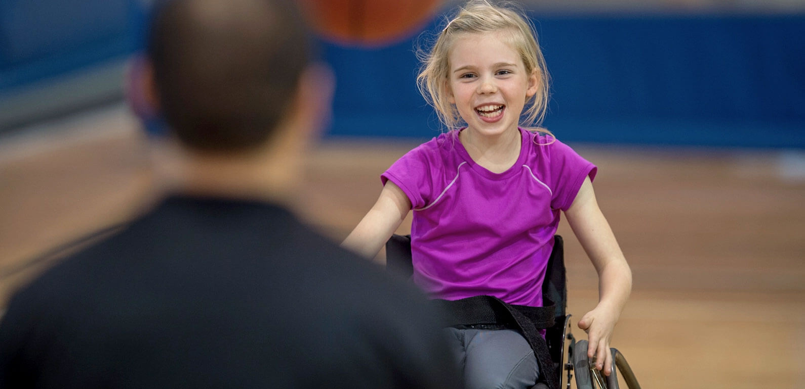 Young girl in wheelchair playing basketball