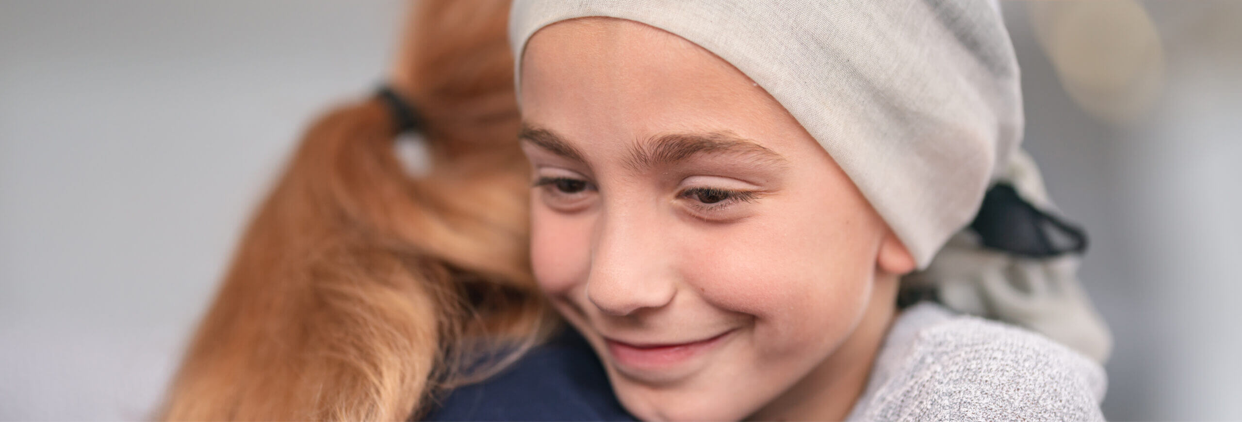Girl with headscarf smiling and hugging healthcare worker