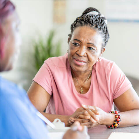 Woman talking to a health worker at a table
